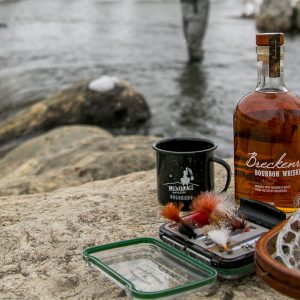 whiskey with fishing lures in front of river